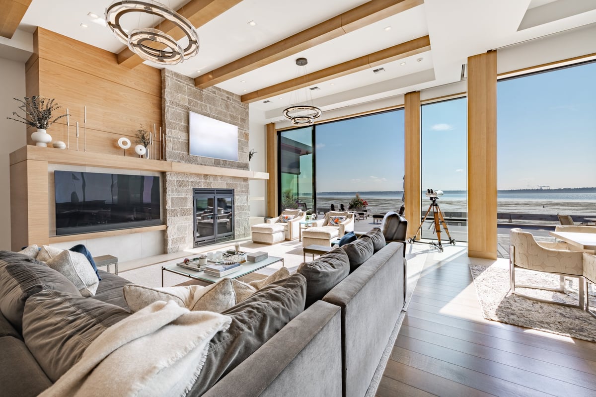 Luxury modern living room with floor to ceiling windows and stone fireplace